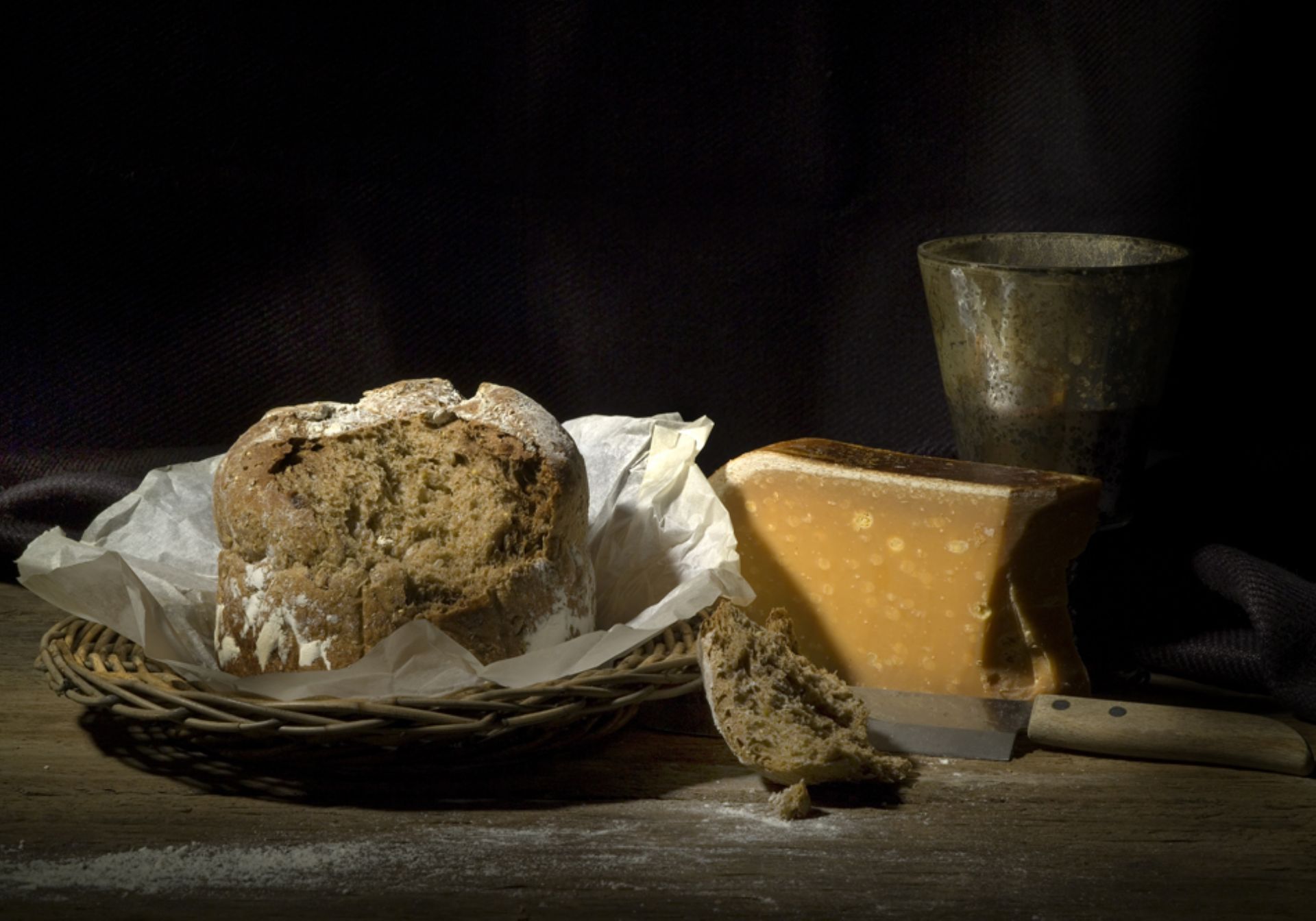 Foto van brood, oude kaas en een beker op tafel 